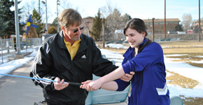 Teacher and coach Mark Smith helps a student better her golf swing. Photo by Henna Danek